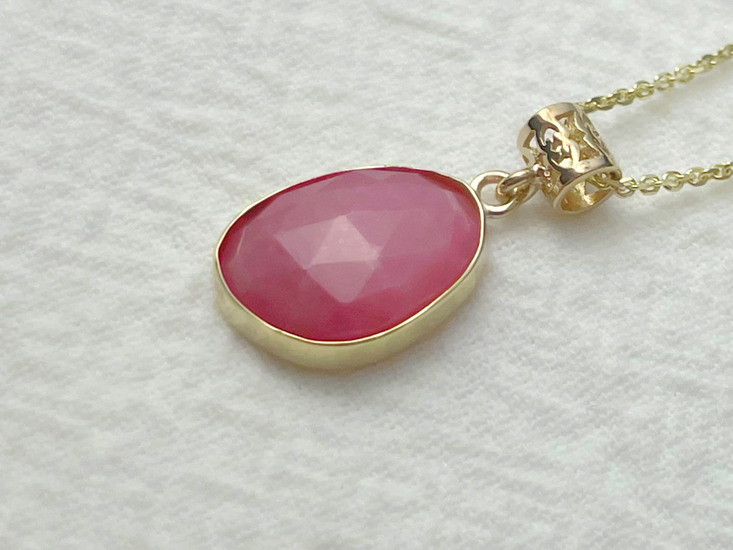 Necklace with a pink pendant on a light gray background
