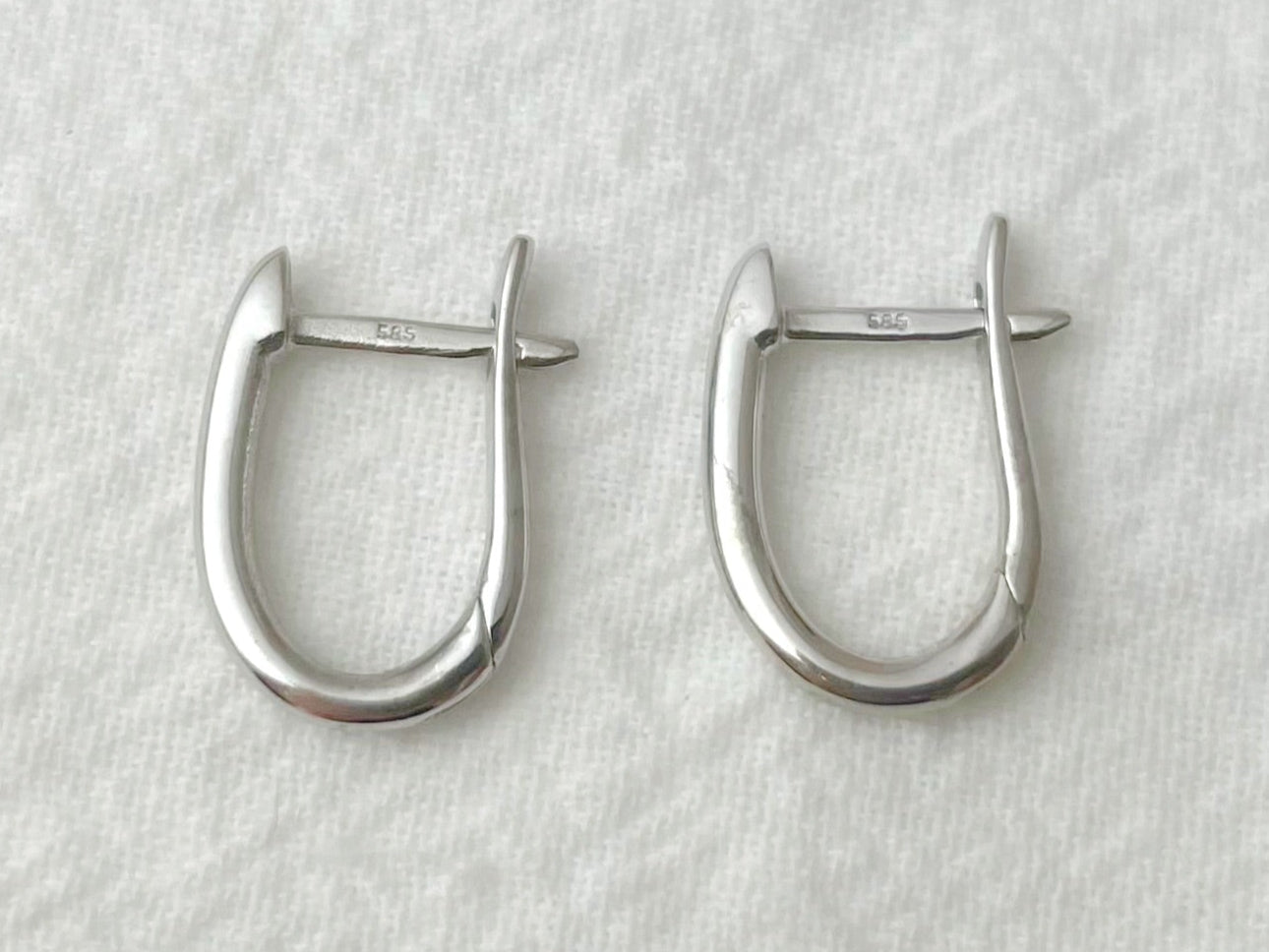 Pair of silver hoop earrings on a light gray background