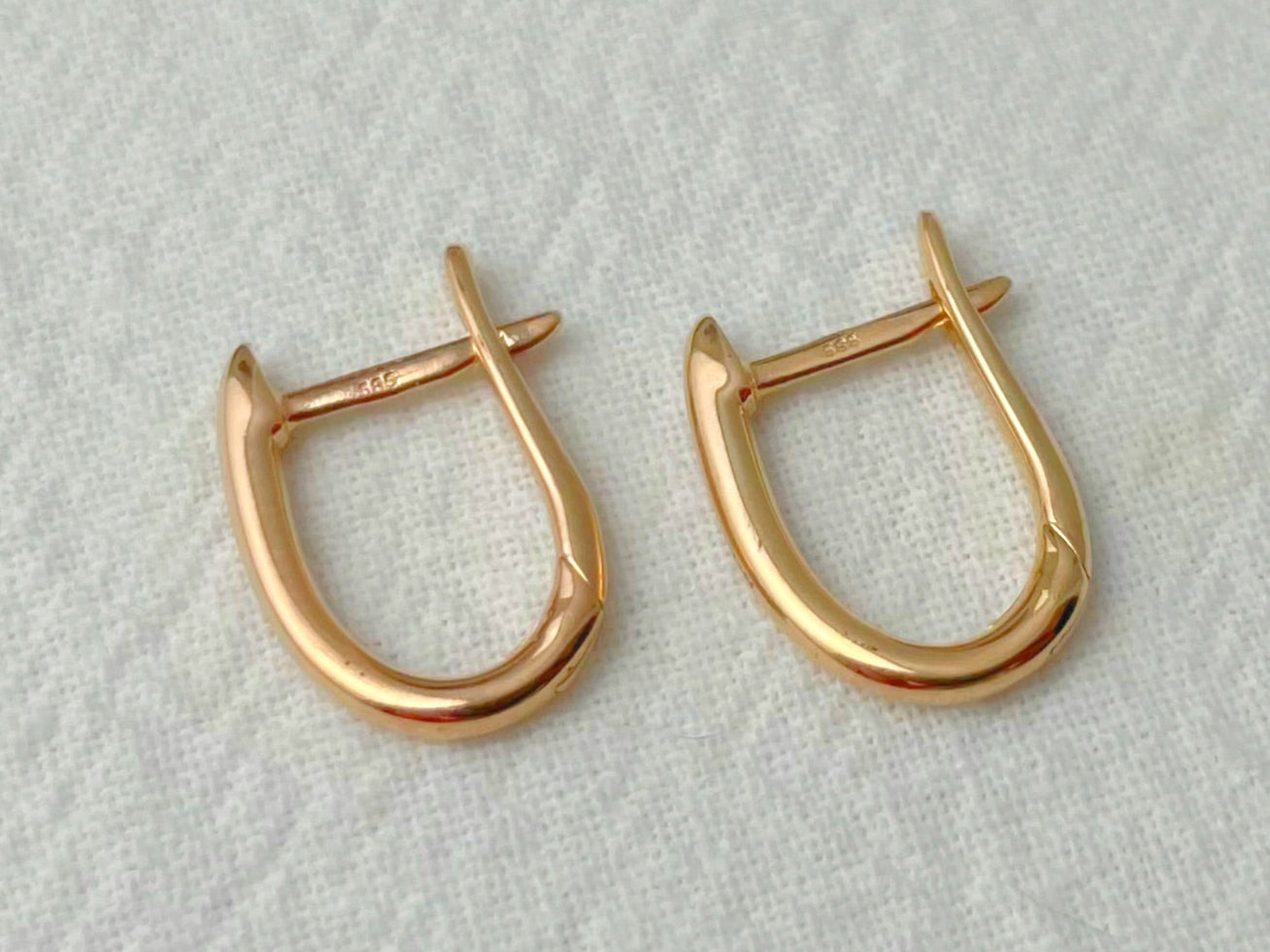 Pair of gold hoop earrings on a light gray background