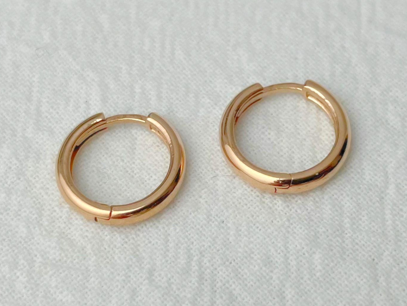 Pair of gold hoop earrings on a light gray background