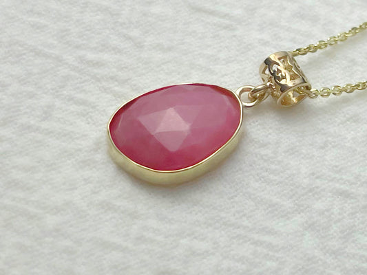 Necklace with a pink pendant on a light gray background