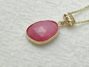 Necklace with a pink pendant on a light gray background