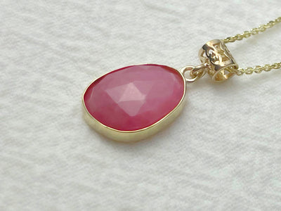 Necklace with a pink pendant on a light gray background