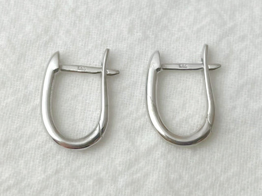 Pair of silver hoop earrings on a light gray background