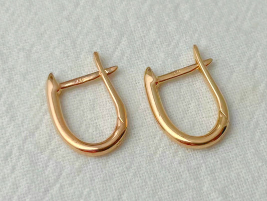 Pair of gold hoop earrings on a light gray background