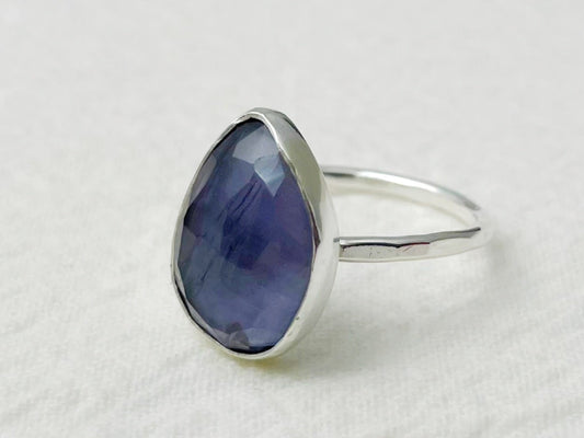 Silver ring with a blue stone on a white background
