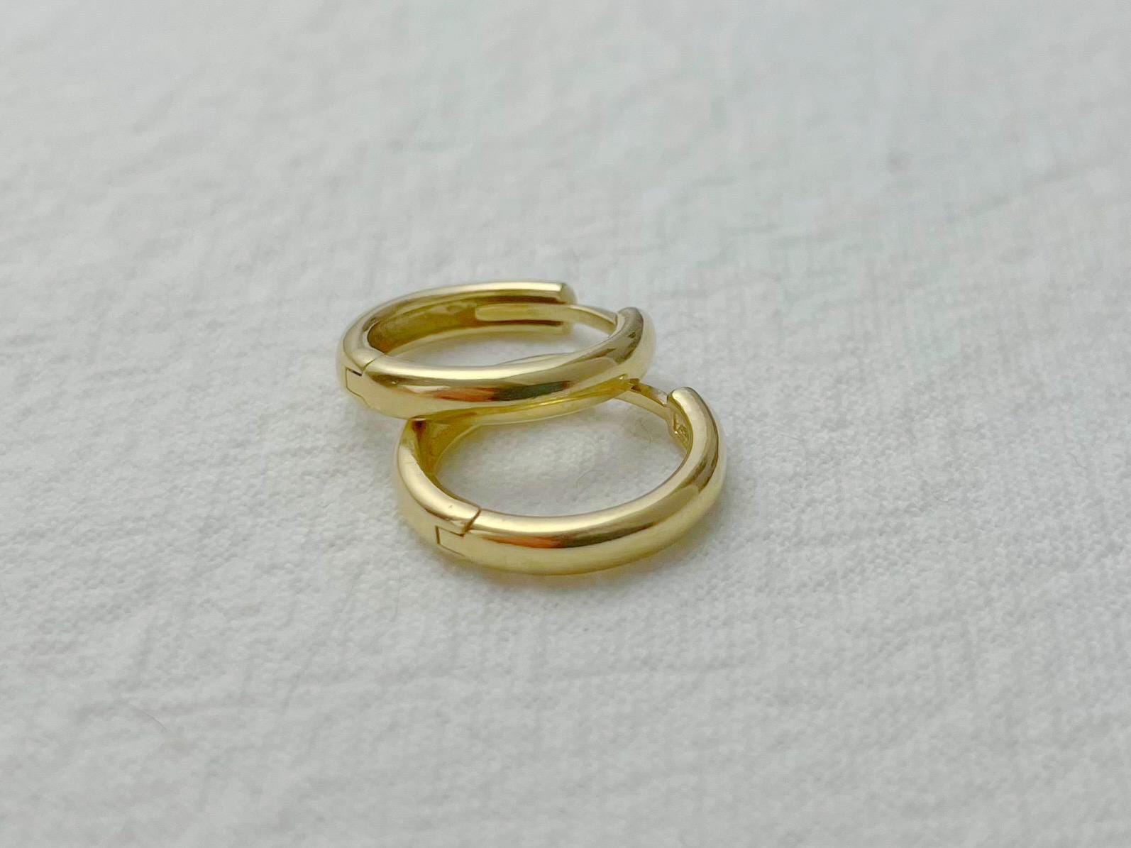 Close-up of small gold hoops with 2.5mm width and seamless hinge clasp