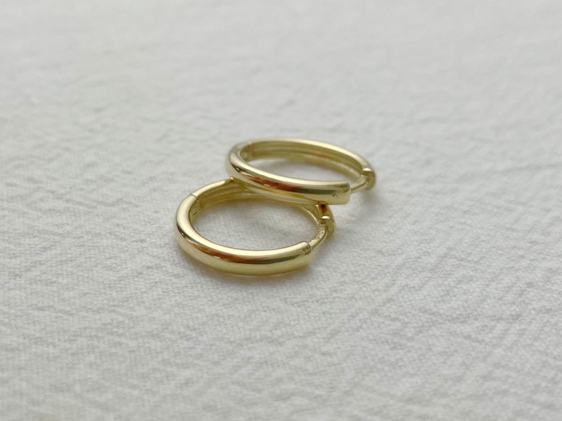 Classic yellow gold hoops, 16mm in diameter and 2.5mm thick, styled flat for detail view