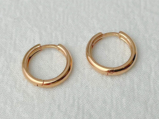 Pair of gold hoop earrings on a light gray background